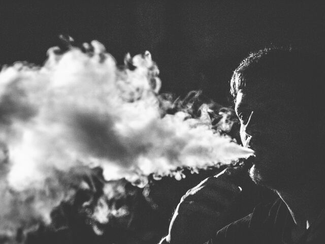 person exhale vape smoke black and white photo